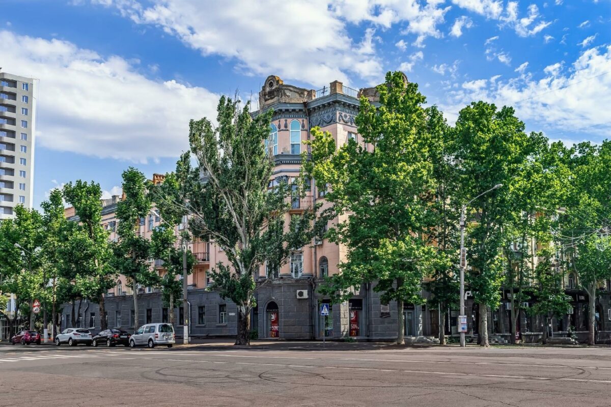 En gammel bygning i Mykolaiv med grønne træer på hjørnet af Soborna og Admiralska gaderne. Foto: Ioanna Alexa/iStock.