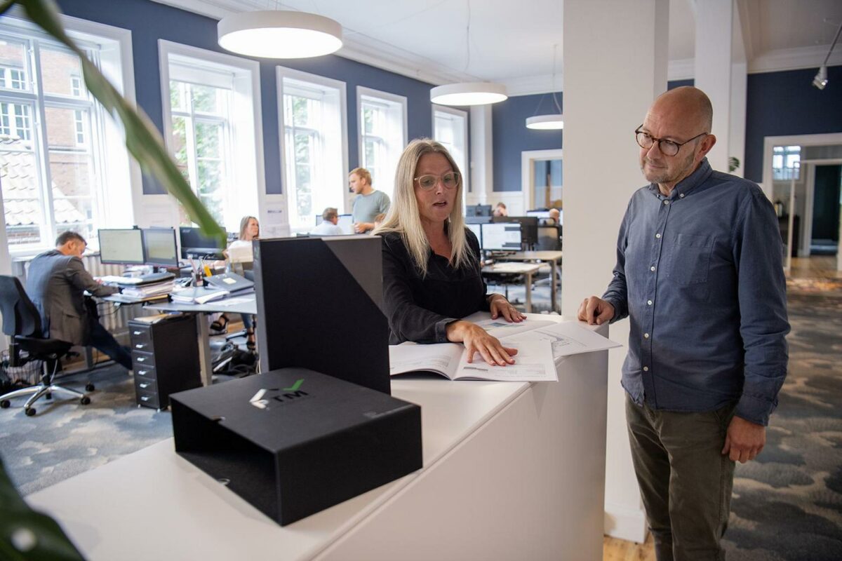 Tagpapbranchens opslagsværk, PTM-anvisningerne, bruges som et værktøj for den projekterende arkitekt. På billedet projektchef Dorthe L. Hartung fra Phønix Tag Materialer og partner og afdelingsleder i Horsens Bo Haugland Andersen fra Arkitektfirmaet Vallentin Haugland A/S. Pressefoto.