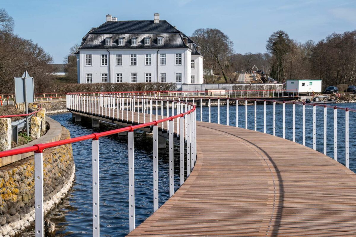 Stien over Hvidkilde Sø set tæt på. Gelænderet der er rødt, snor sig langs broen.