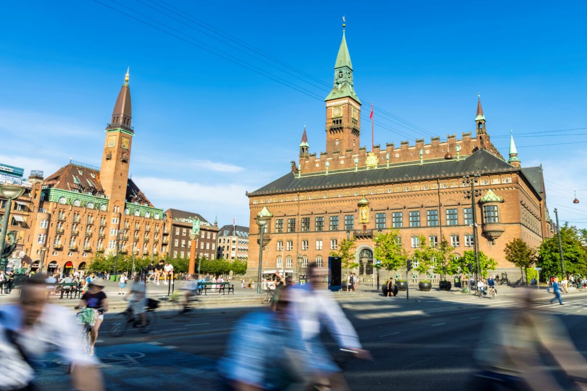 Slørede cyklister suser forbi Københavns Rådhus.